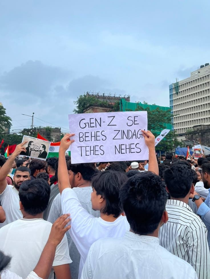 Protester holding a sign: Gen-Z se behes, zindagi tehes nehes